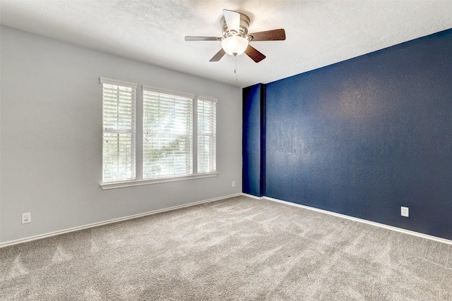 empty room with ceiling fan, carpet, and a textured ceiling