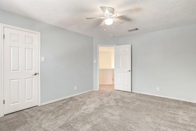 carpeted spare room with a textured ceiling and ceiling fan