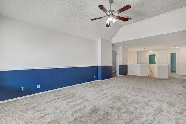 spare room with a textured ceiling, ceiling fan, carpet floors, and lofted ceiling