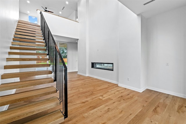 2206 Trail Of The Madrones, Austin, TX 78746 - stairs with a high ceiling, hardwood / wood-style flooring, and ceiling fan