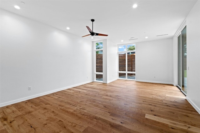 2206 Trail Of The Madrones, Austin, TX 78746 - unfurnished living room featuring floor to ceiling windows, light hardwood / wood-style floors, and ceiling fan