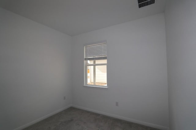 spare room with dark colored carpet