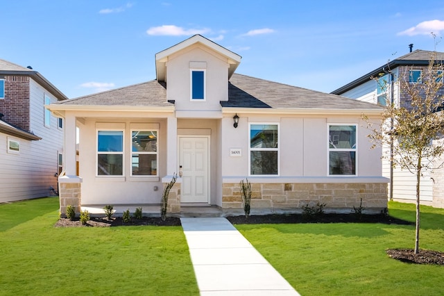 view of front of property with stone siding, a front lawn, roof with shingles, and stucco siding