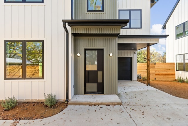 doorway to property with a carport and a garage