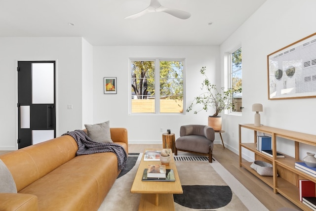 living room featuring ceiling fan and light hardwood / wood-style floors