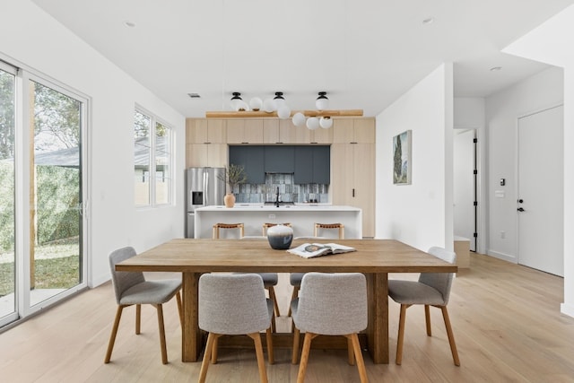 dining area featuring light wood-type flooring and sink