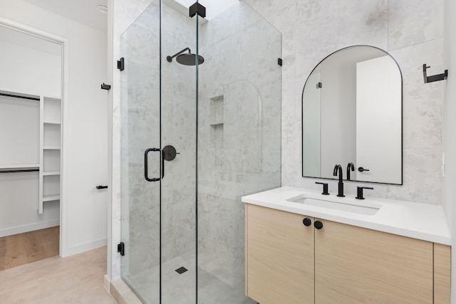 bathroom with vanity, wood-type flooring, and a shower with door