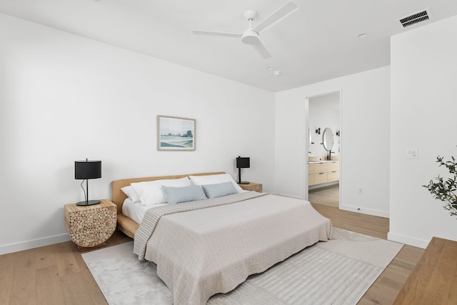 bedroom featuring connected bathroom, light hardwood / wood-style floors, and ceiling fan