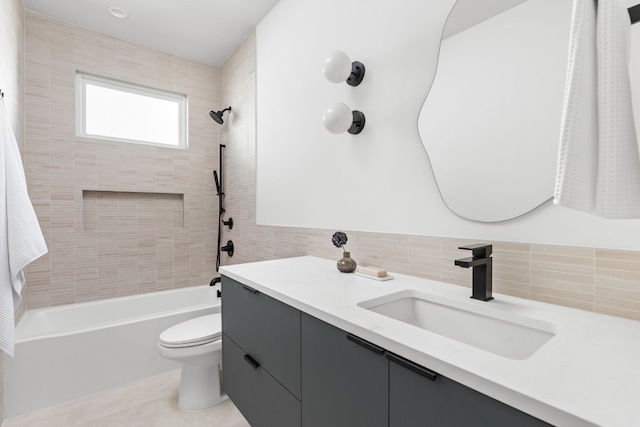 full bathroom featuring tile patterned floors, vanity, tile walls, toilet, and tiled shower / bath