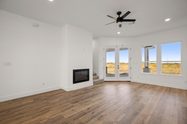 unfurnished living room with dark hardwood / wood-style floors, ceiling fan, and french doors