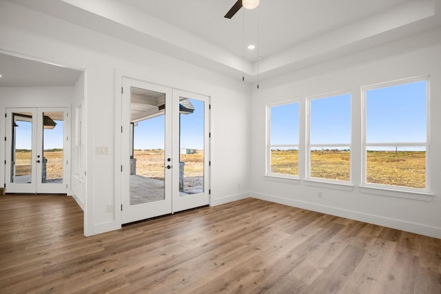 empty room featuring ceiling fan, french doors, and hardwood / wood-style flooring