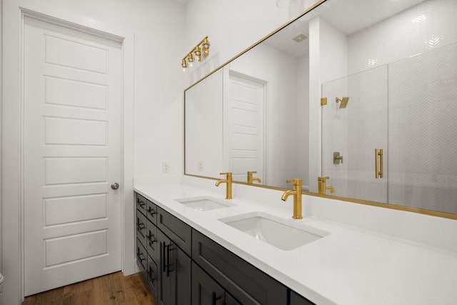 bathroom with a shower with shower door, wood-type flooring, and vanity