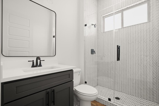 bathroom featuring vanity, toilet, and walk in shower