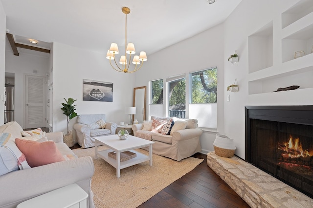 living room with a fireplace, a high ceiling, dark hardwood / wood-style flooring, and an inviting chandelier