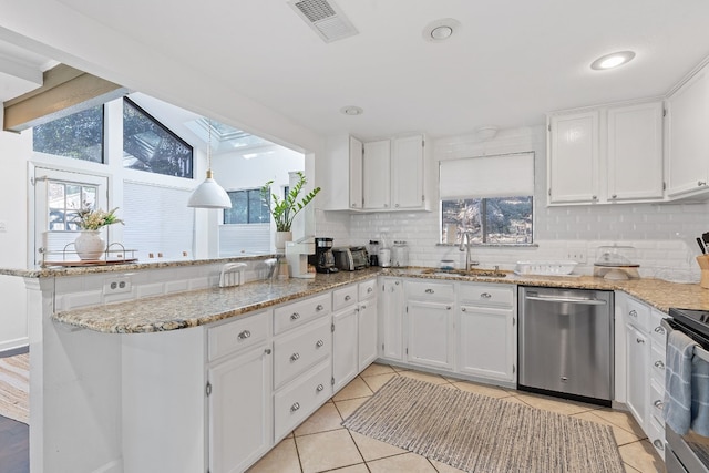 kitchen with sink, appliances with stainless steel finishes, white cabinetry, backsplash, and kitchen peninsula