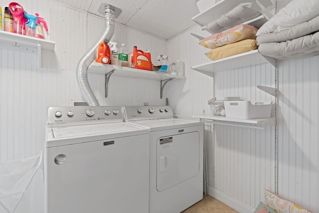 washroom featuring light tile patterned flooring, independent washer and dryer, and wood walls