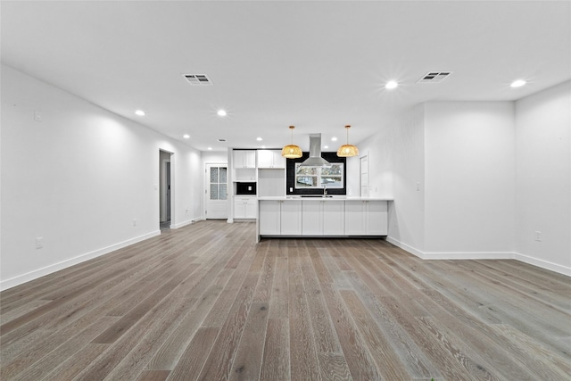 unfurnished living room with light wood-type flooring and sink