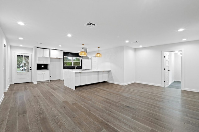 unfurnished living room featuring hardwood / wood-style floors and sink