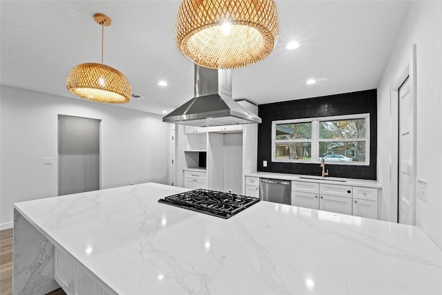 kitchen with ventilation hood, sink, hanging light fixtures, light stone countertops, and appliances with stainless steel finishes