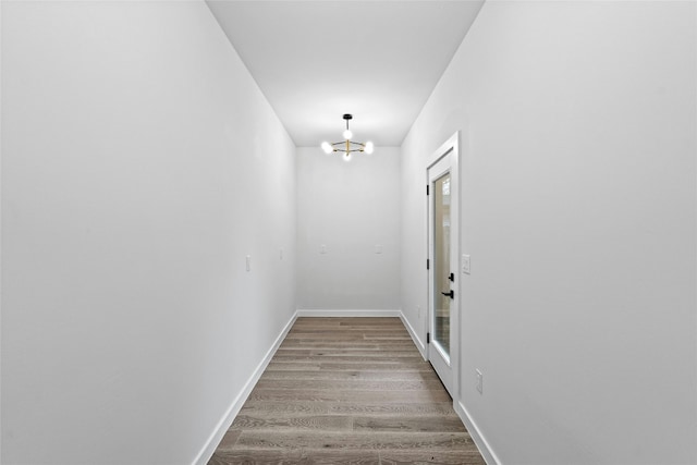 hall featuring a notable chandelier and light wood-type flooring