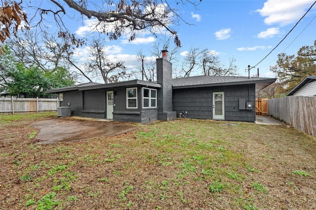 back of property with a yard, central AC, and a patio area