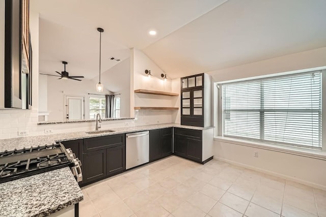 kitchen with light stone countertops, sink, ceiling fan, hanging light fixtures, and stainless steel appliances