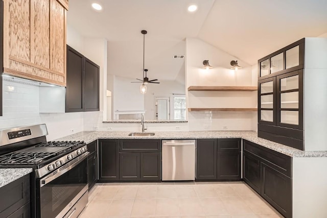 kitchen featuring light stone counters, sink, stainless steel appliances, and lofted ceiling