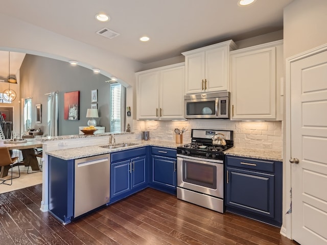 kitchen with blue cabinetry, dark hardwood / wood-style flooring, white cabinetry, and stainless steel appliances