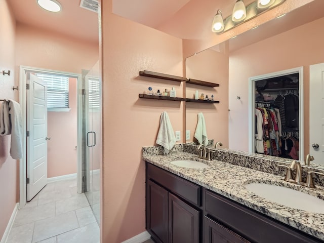 bathroom featuring tile patterned flooring, vanity, and a shower with door