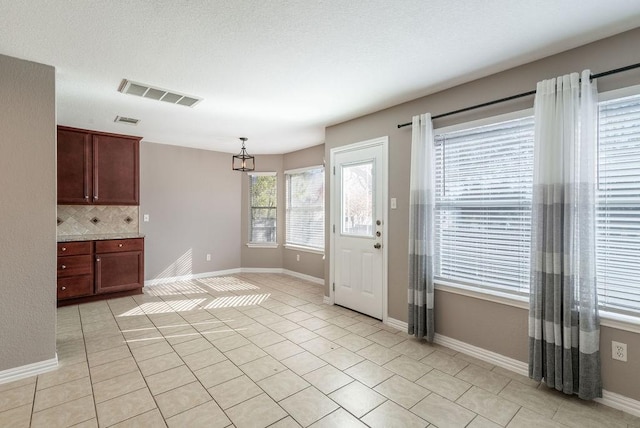 kitchen featuring light tile patterned floors, hanging light fixtures, and tasteful backsplash