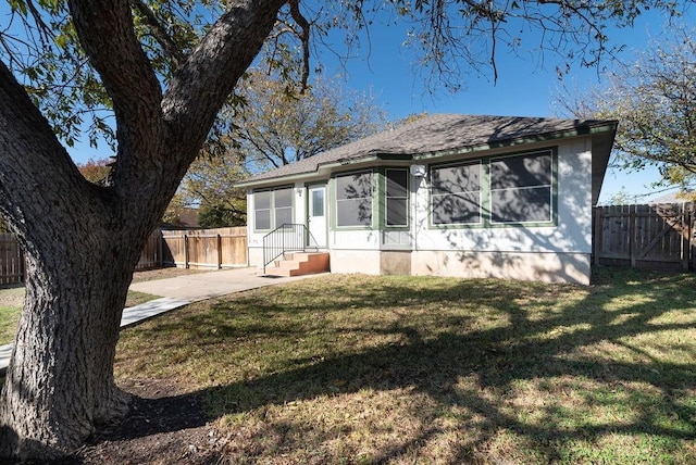 back of property featuring a lawn