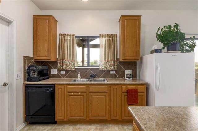 kitchen with tasteful backsplash, sink, white refrigerator, and black dishwasher