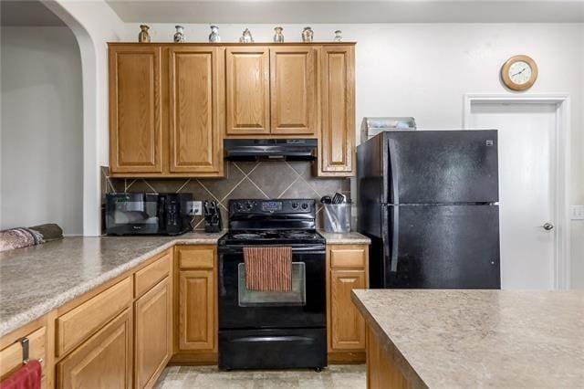 kitchen featuring black appliances and tasteful backsplash