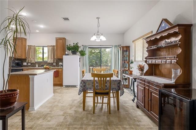 kitchen with pendant lighting, an inviting chandelier, a healthy amount of sunlight, and white refrigerator