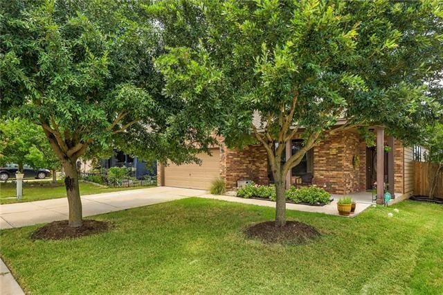 view of property hidden behind natural elements featuring a front yard