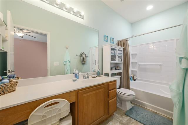 full bathroom featuring ceiling fan, vanity, shower / tub combo, and toilet