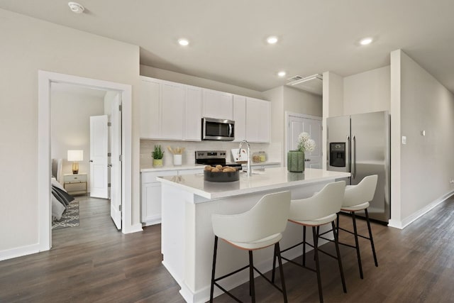 236 Lazy Lizzy Rd, Jarrell, TX 76537 - kitchen featuring appliances with stainless steel finishes, an island with sink, backsplash, white cabinets, and recessed lighting