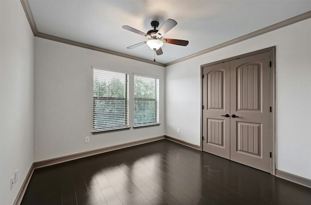 unfurnished bedroom with crown molding, ceiling fan, dark hardwood / wood-style floors, a textured ceiling, and a closet