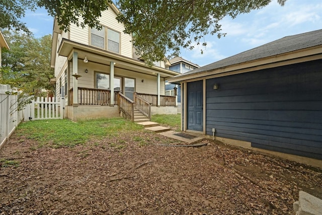 rear view of property featuring covered porch