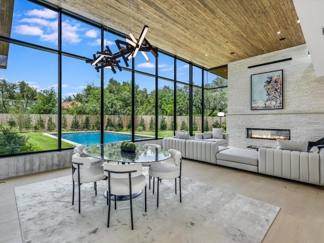 sunroom / solarium with a stone fireplace and wooden ceiling