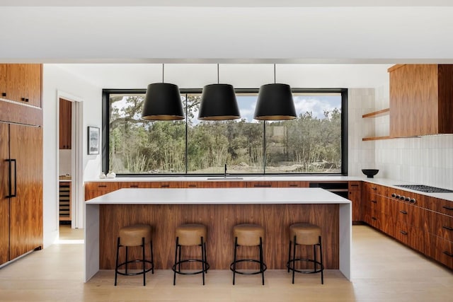 kitchen with pendant lighting, a breakfast bar area, and paneled built in fridge