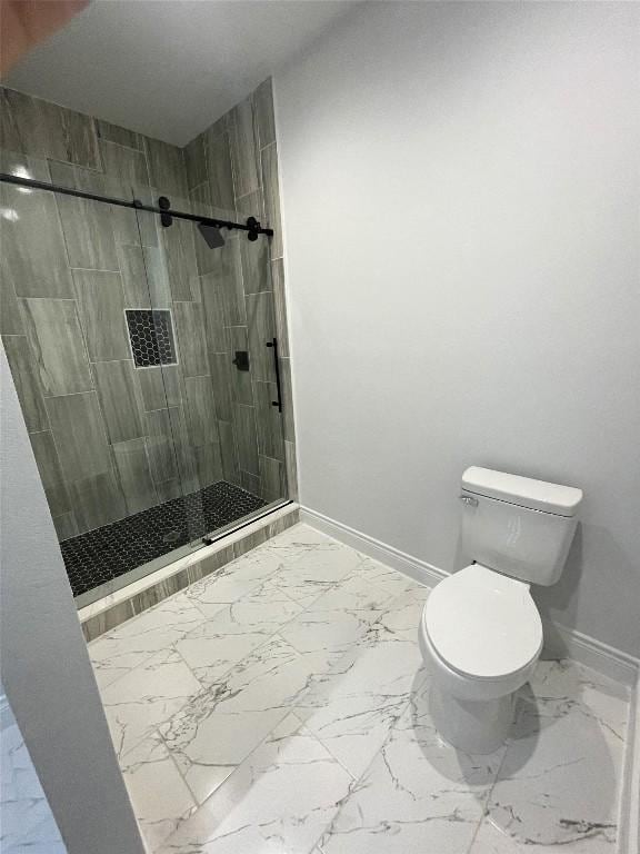 bathroom featuring tiled shower and toilet