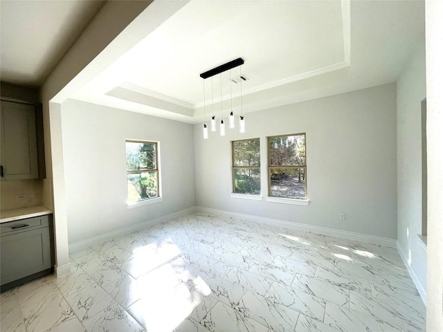 unfurnished dining area featuring crown molding and a tray ceiling