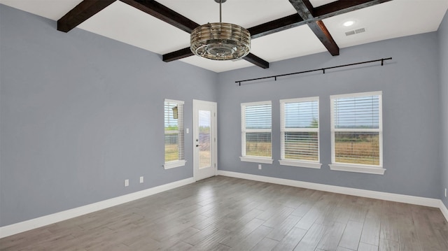 unfurnished room featuring beamed ceiling and light hardwood / wood-style floors