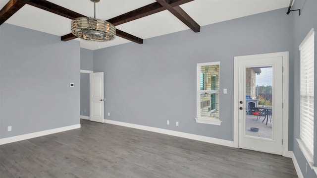 spare room with beam ceiling, baseboards, and wood finished floors