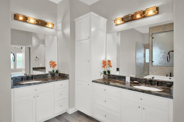 bathroom featuring a shower with shower door, wood-type flooring, and vanity