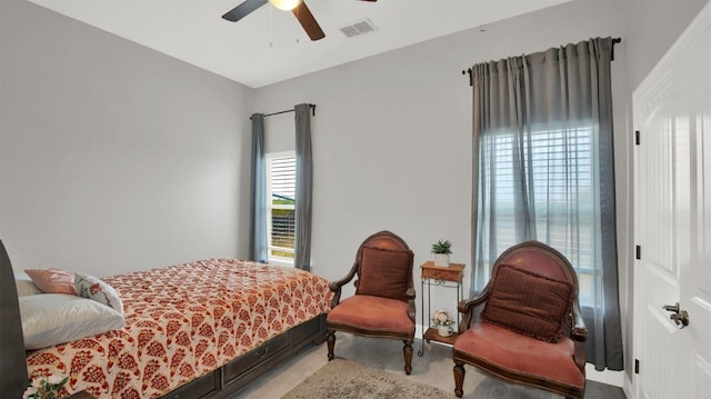 bedroom with light wood-style flooring, visible vents, and ceiling fan