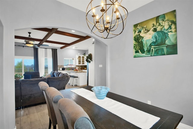 dining room with arched walkways, beam ceiling, a ceiling fan, light wood-type flooring, and coffered ceiling