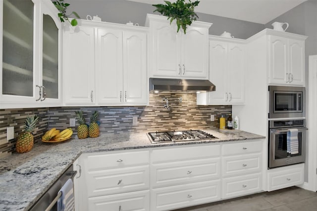 kitchen featuring white cabinets, appliances with stainless steel finishes, backsplash, and light stone counters