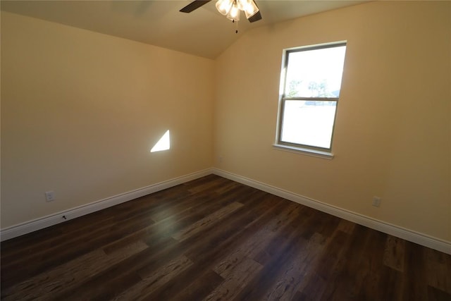 spare room with vaulted ceiling, ceiling fan, and dark wood-type flooring